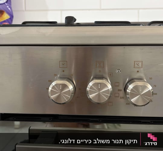 כפתורי שליטה על תנור אפייה עם סימונים לטמפרטורה ותוכניות.